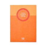 bright orange notebook with a quote about positivity.
